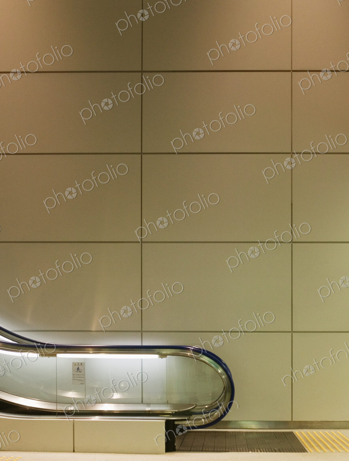 Panelled wall behind escalator in airport.