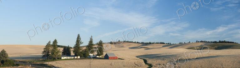 Panoramic view of a farming landscape, a red painted Dutch barn and farm buildings, a…