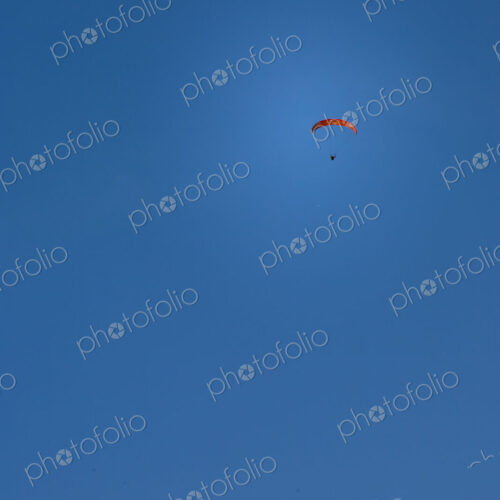 Paraglider above Yakima Canyon with a colourful canopy floating in a blue sky. Paraglider above Yakima Canyon with a colourful canopy floating in a blue sky.