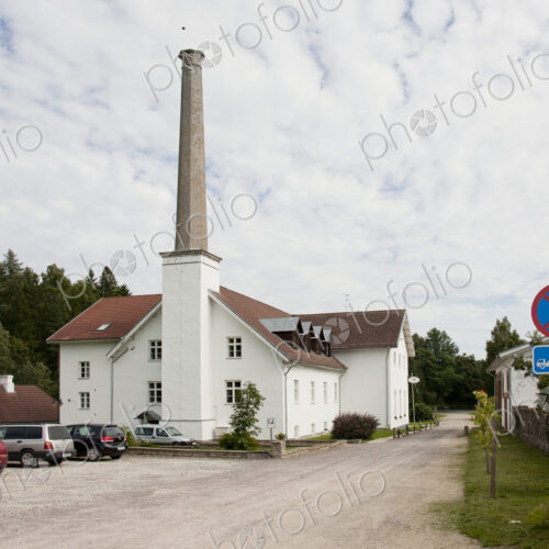 Parking Lot of Building With a Tall Smokestack Parking Lot of Building With a Tall Smokestack