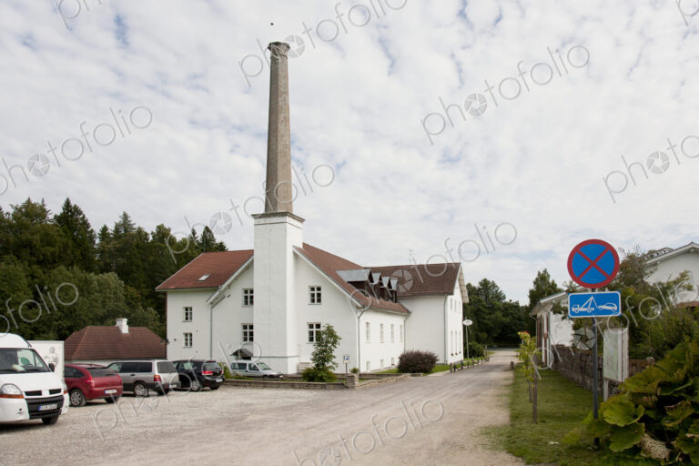 Parking Lot of Building With a Tall Smokestack