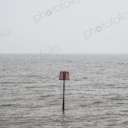 Partially submerged metal marker pole in the ocean. Partially submerged metal marker pole in the ocean.