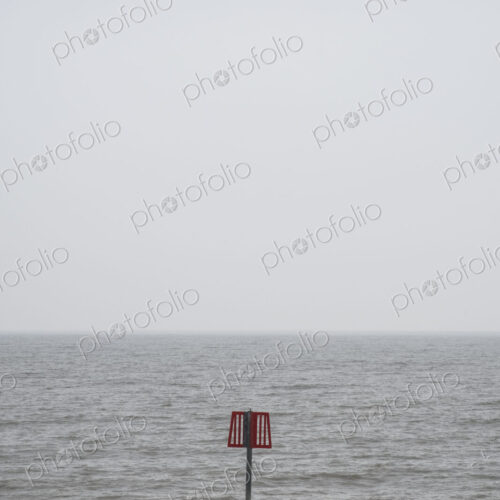 Partially submerged metal marker pole in the ocean. Partially submerged metal marker pole in the ocean.