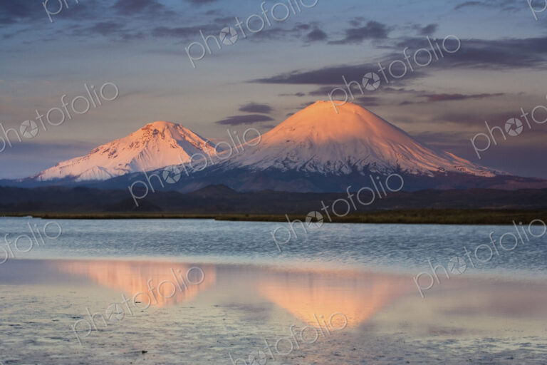 Payachata Volcanoes, twin volcanoes each standing over twenty thousand feet high,…