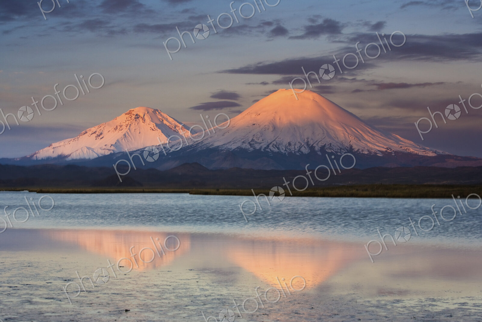 Payachata Volcanoes, twin volcanoes each standing over twenty thousand feet high,…