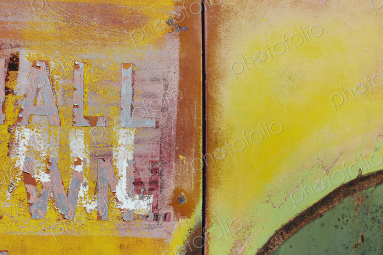 Peeling lettering and paint on side of old, abandoned truck