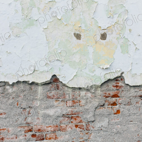 Peeling paint and exposed old brick wall