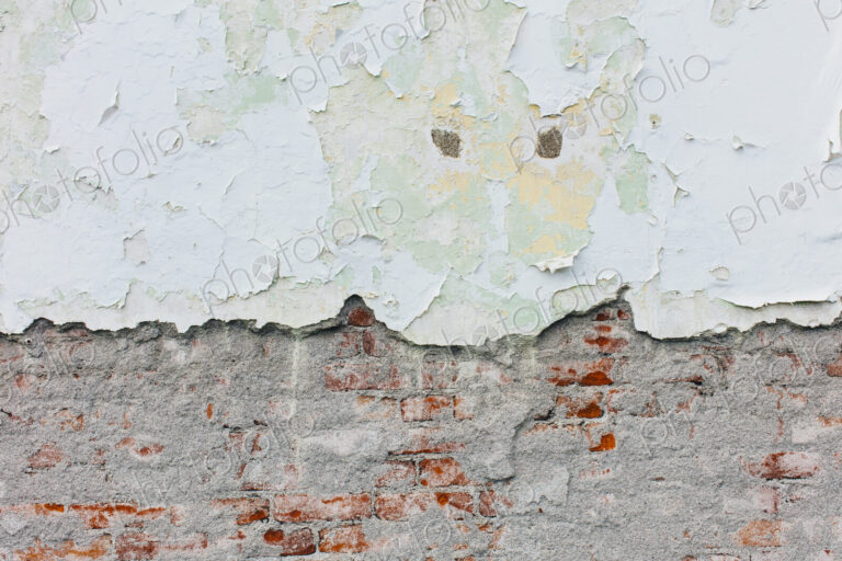 Peeling paint and exposed old brick wall
