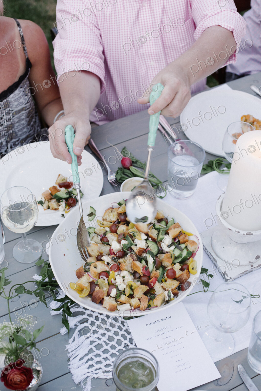 People around a table at a garden party, a bowl of salad.
