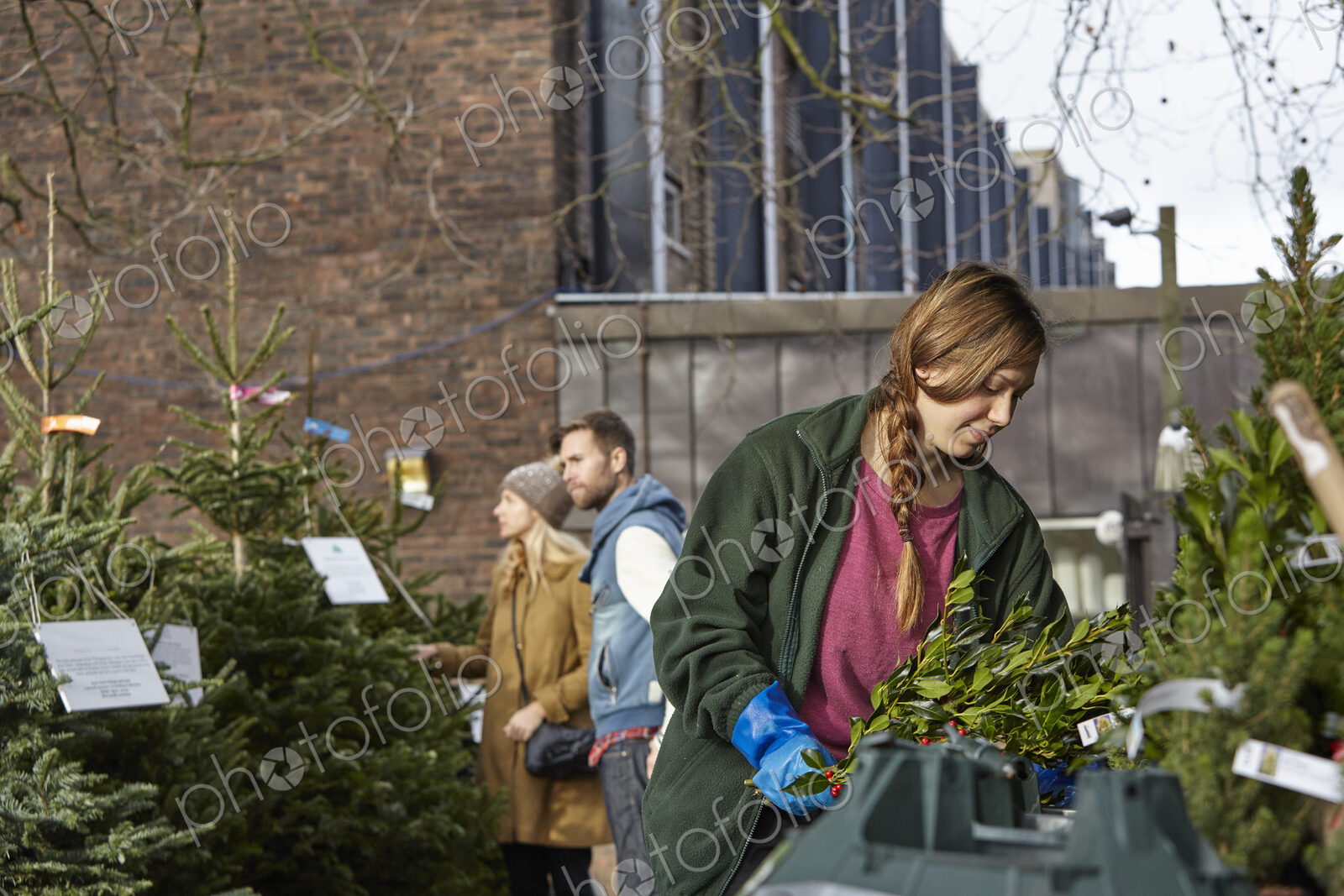 People at a garden centre shopping for a Christmas tree.