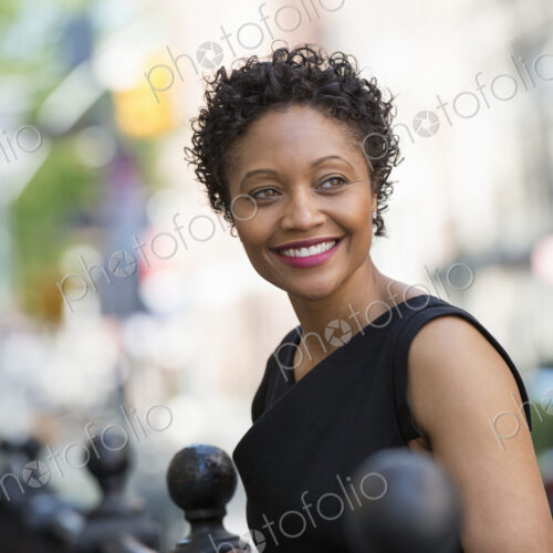 People on the move. A woman in a black dress on a city street. People on the move. A woman in a black dress on a city street.