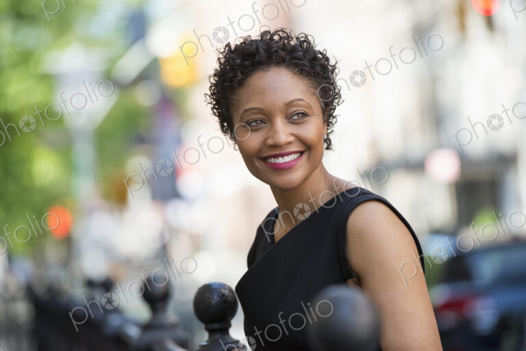 People on the move. A woman in a black dress on a city street.