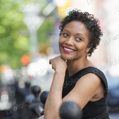 People on the move. A woman in a black dress on a city street. People on the move. A woman in a black dress on a city street.