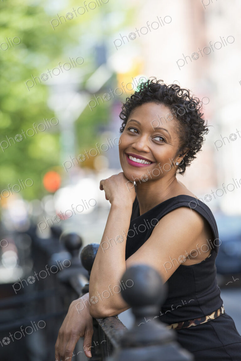 People on the move. A woman in a black dress on a city street.