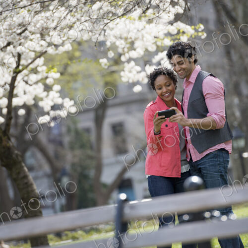 People outdoors in the city in spring time. New York City park. A man and woman side… People outdoors in the city in spring time. New York City park. A man and woman side…