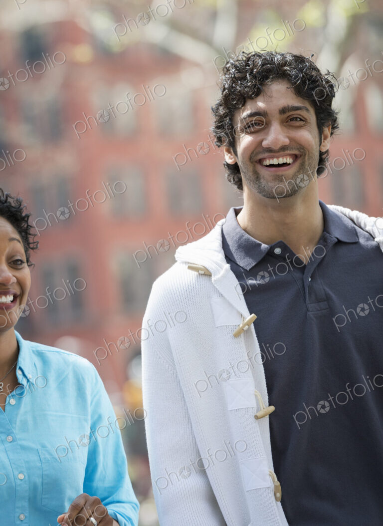 People outdoors in the city in spring time. New York City park. A man and woman side…