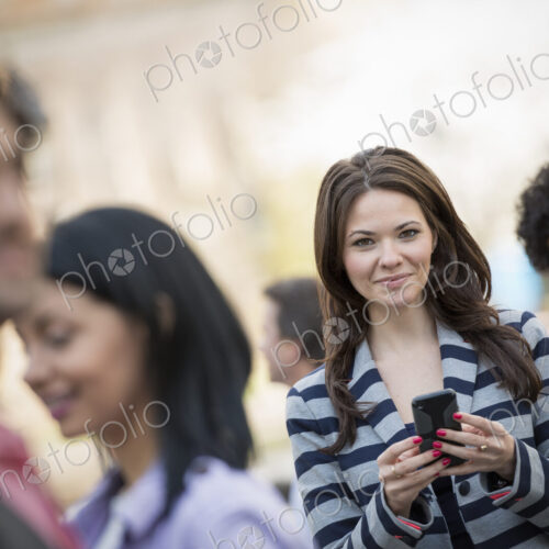 People outdoors in the city in spring time. New York City park. A young woman holding… People outdoors in the city in spring time. New York City park. A young woman holding…