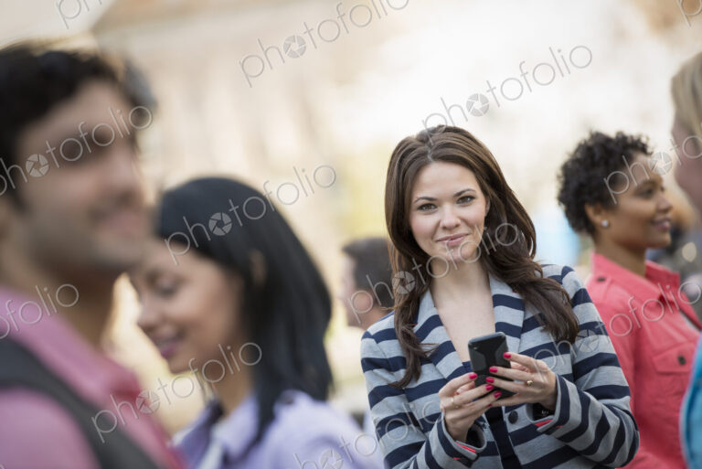 People outdoors in the city in spring time. New York City park. A young woman holding…