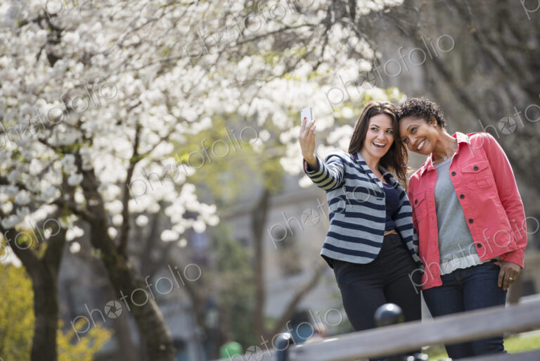 People outdoors in the city in spring time. New York City park. A young woman holding…