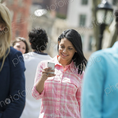 People outdoors in the city in spring time. New York City park. Three women, one… People outdoors in the city in spring time. New York City park. Three women, one…