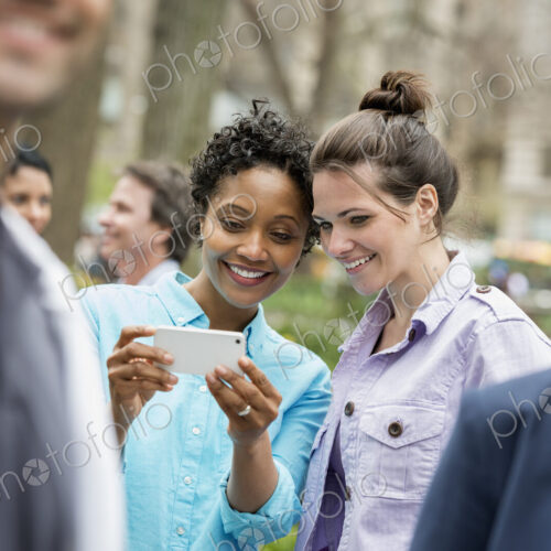 People outdoors in the city in spring time. New York City park. Two women in a group… People outdoors in the city in spring time. New York City park. Two women in a group…