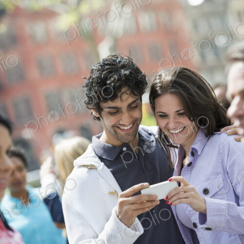 People outdoors in the city in spring time. New York City. A group of men and women, a… People outdoors in the city in spring time. New York City. A group of men and women, a…