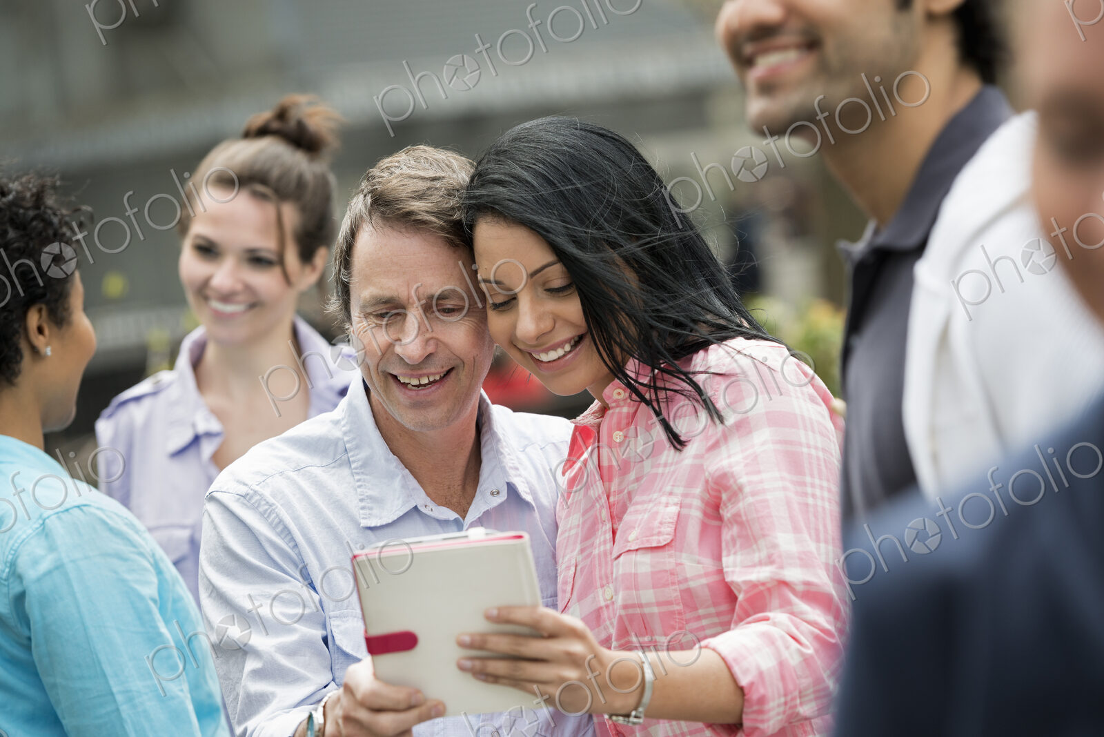 People outdoors in the city in spring time. New York City. A group of men and women, a…