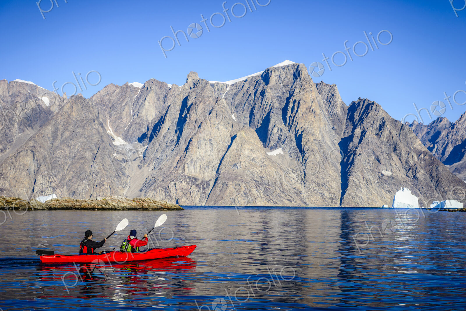 People paddling canoe near rock formations in remote river