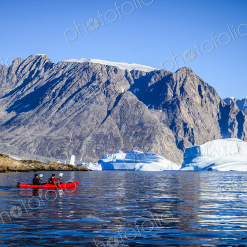People paddling canoe near rock formations in remote river People paddling canoe near rock formations in remote river