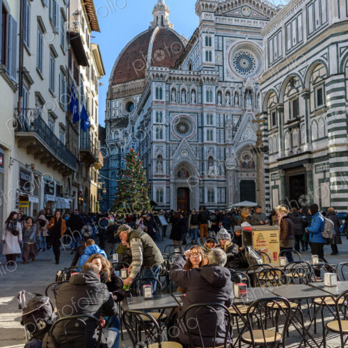 People sitting in a cafe near the Duomo in Florence, the baptistry with a marble… People sitting in a cafe near the Duomo in Florence, the baptistry with a marble…