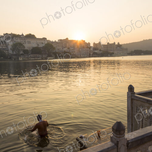 People swimming in a lake in early morning.