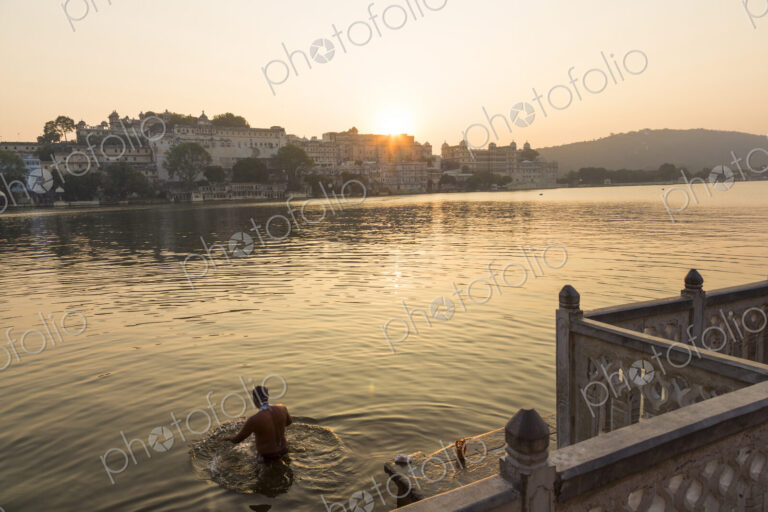 People swimming in a lake in early morning.