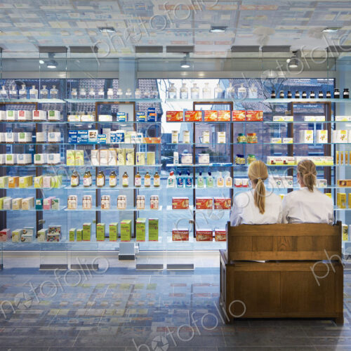 Pharmacists sitting in modern pharmacy Pharmacists sitting in modern pharmacy