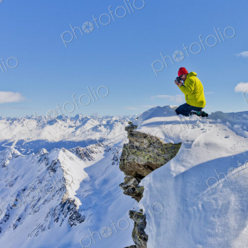 Photographer photographing from snowy mountaintop