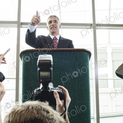 Photographers taking photographs at a political gathering and speech. Photographers taking photographs at a political gathering and speech.