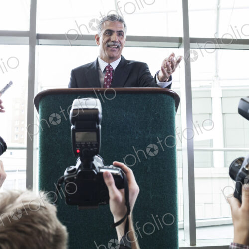 Photographers taking photographs at a political gathering and speech. Photographers taking photographs at a political gathering and speech.