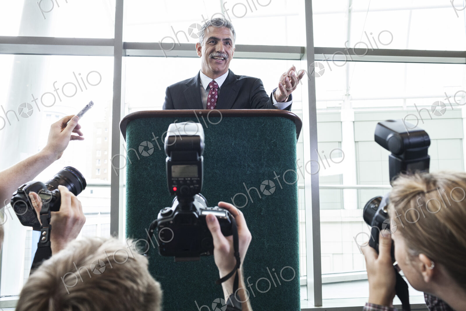 Photographers taking photographs at a political gathering and speech.