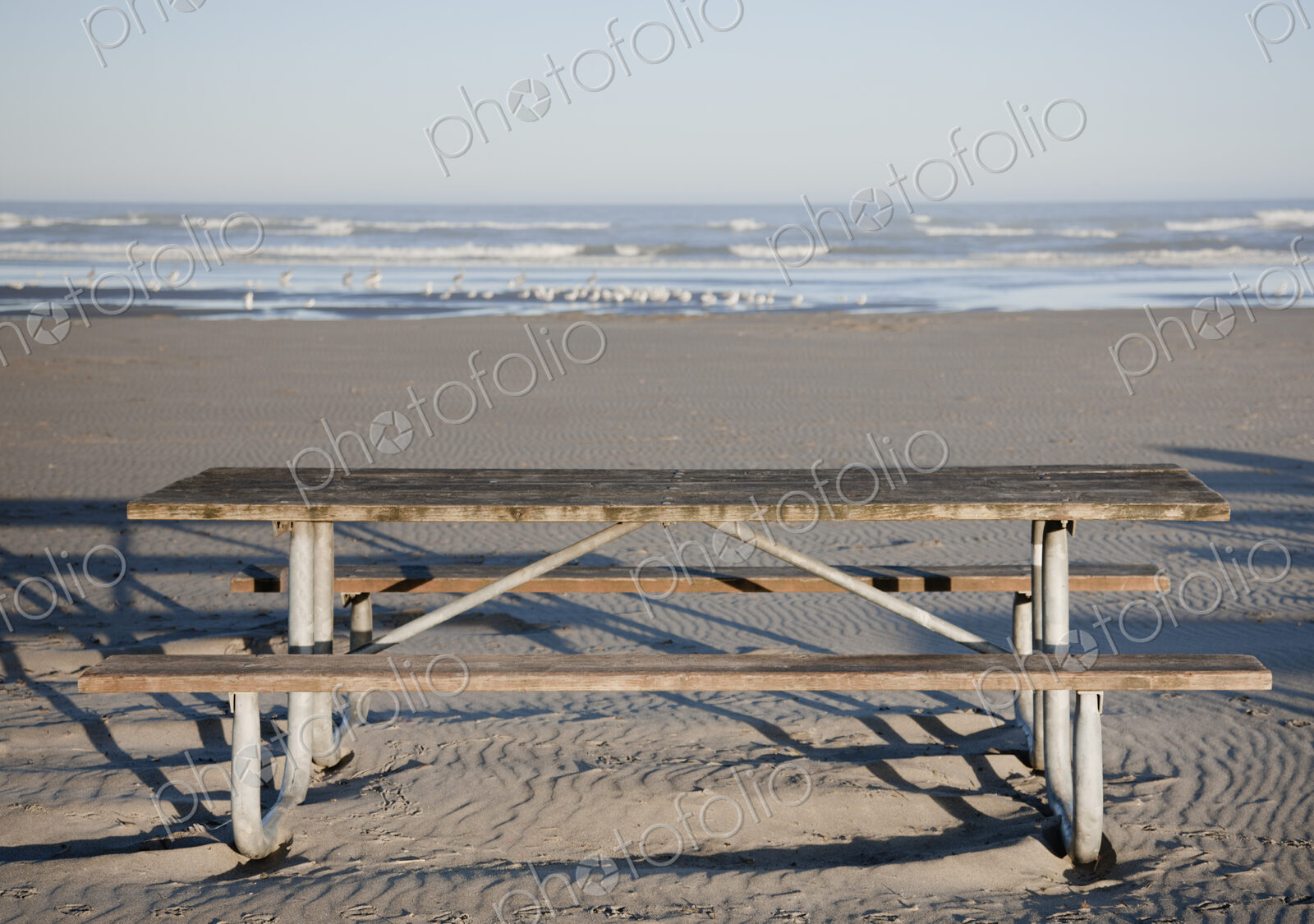 Picnic table on sandy beach.