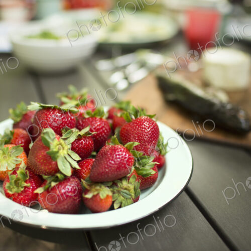 Picnic table with a meal laid out. A place of fresh strawberries. Picnic table with a meal laid out. A place of fresh strawberries.