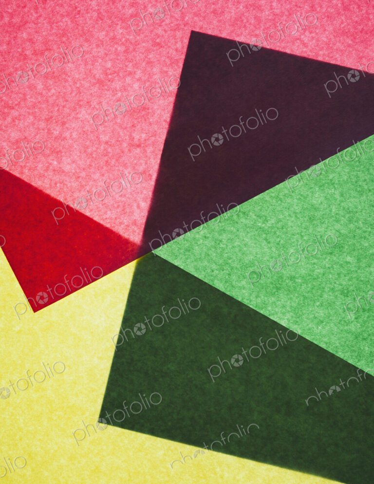 Pieces of colorful, recycled construction paper, overlapping and laid out at random.