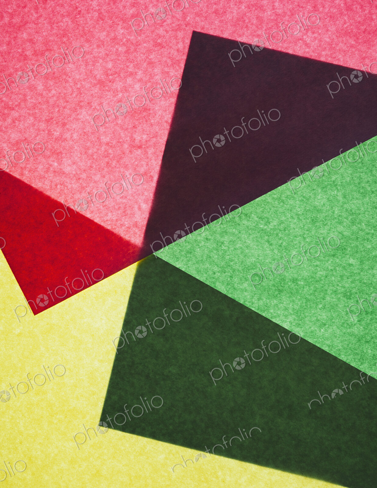 Pieces of colorful, recycled construction paper, overlapping and laid out at random.