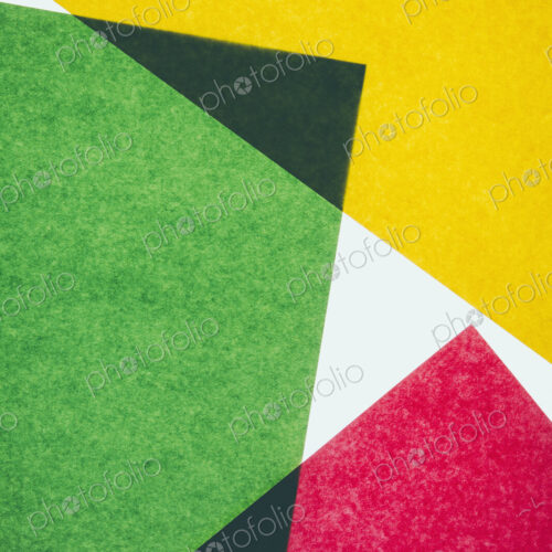 Pieces of colorful, recycled construction paper, overlapping and laid out at random.