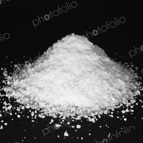 Pile of coarse sea salt grains on a black background. Pile of coarse sea salt grains on a black background.