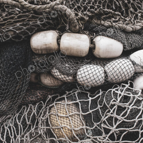 Pile of commercial fishing nets and gill nets on a fishing quay.