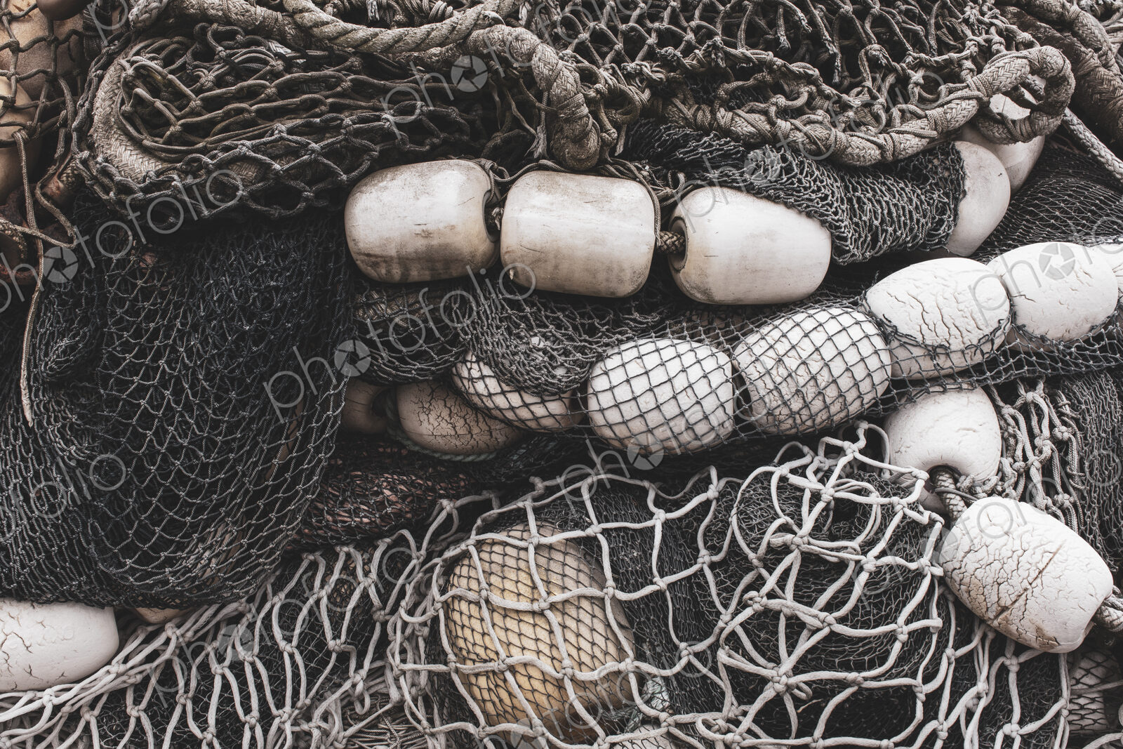 Pile of commercial fishing nets and gill nets on a fishing quay.