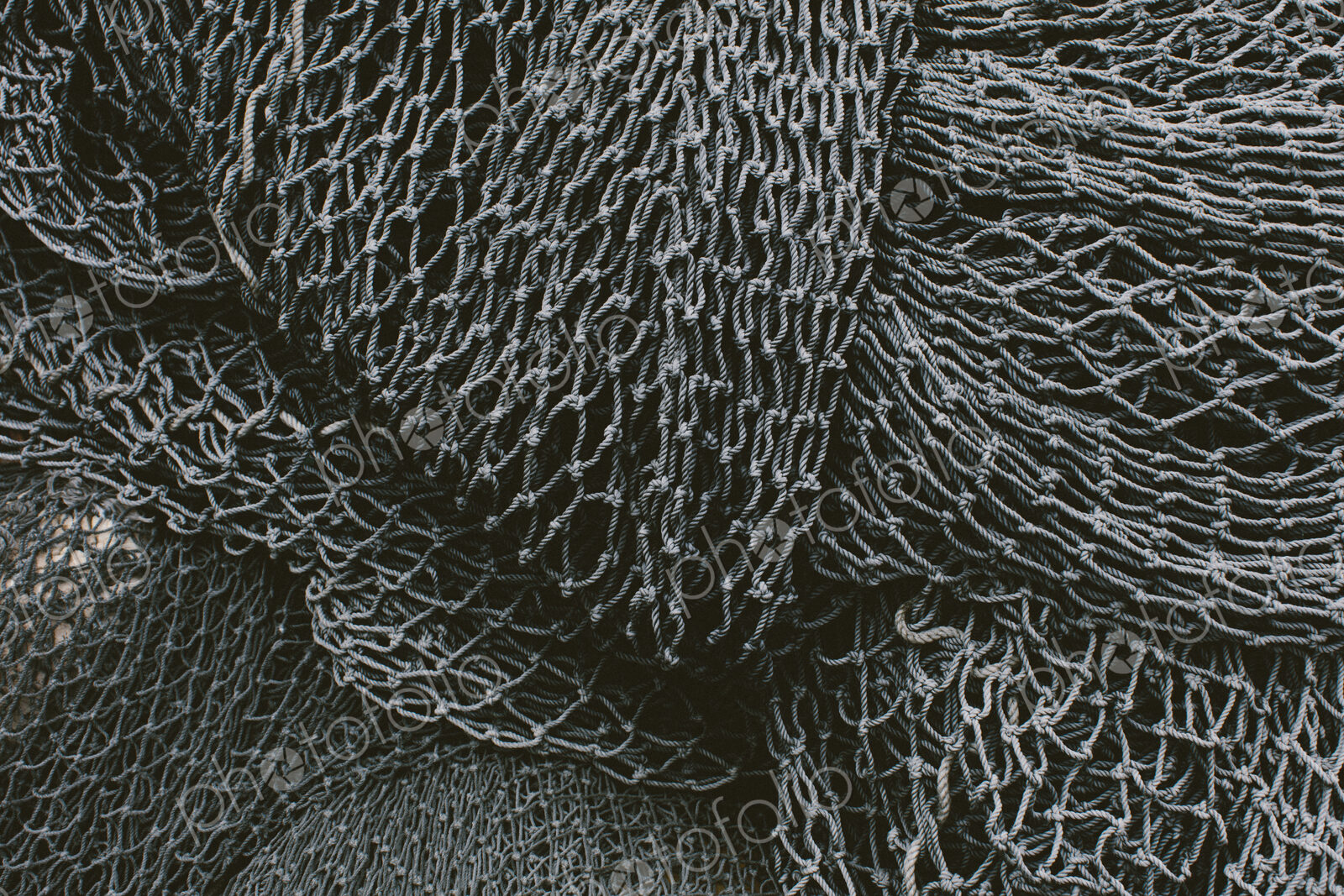Pile of commercial fishing nets and gill nets on a fishing quay.