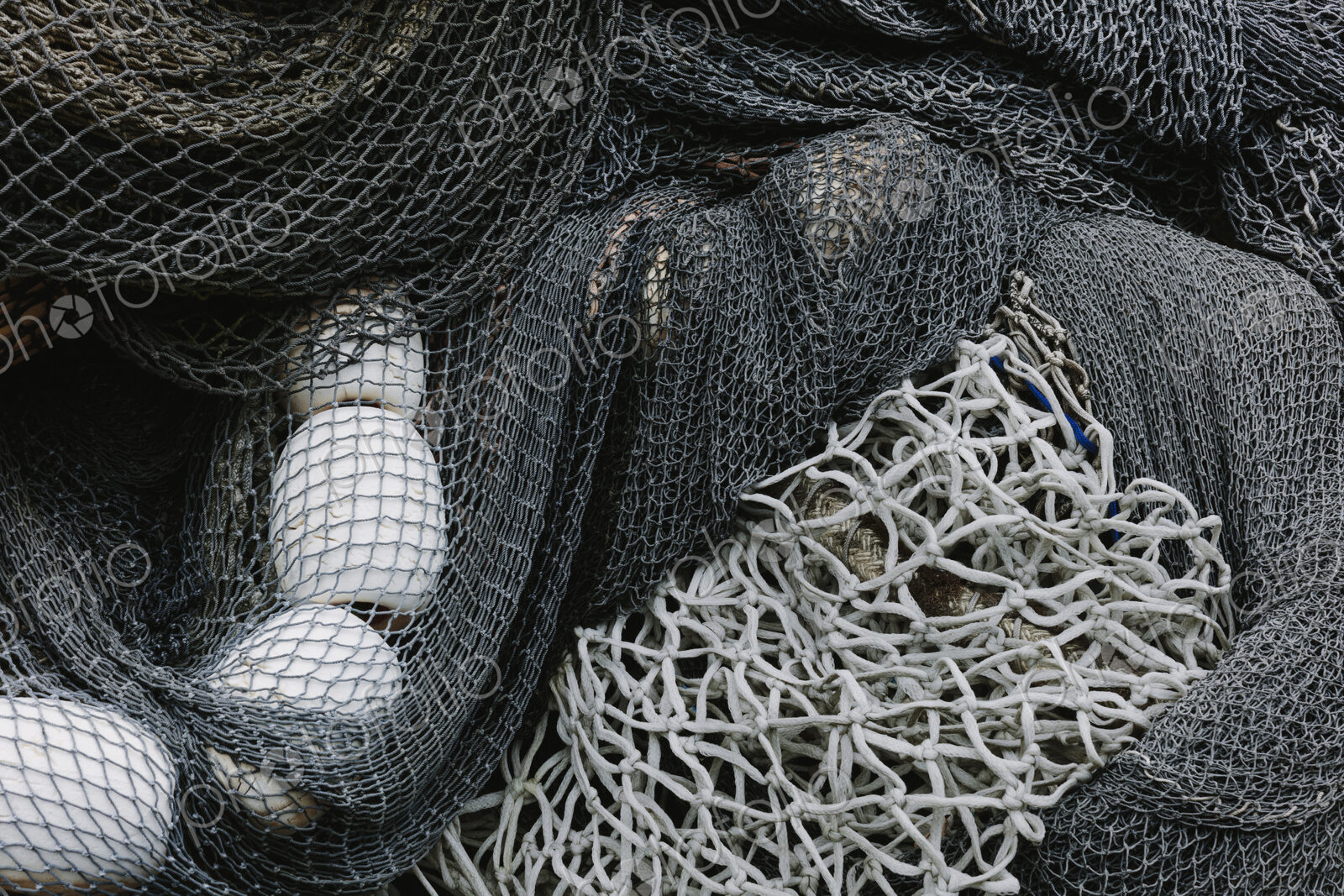 Pile of commercial fishing nets and gill nets on a fishing quay.
