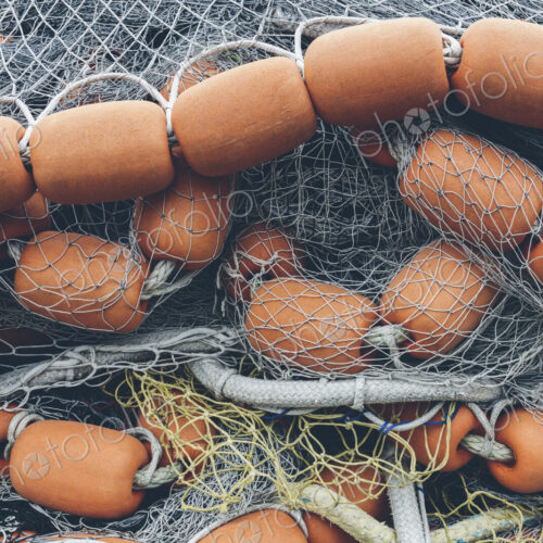Pile of commercial fishing nets and gill nets on a fishing quay.