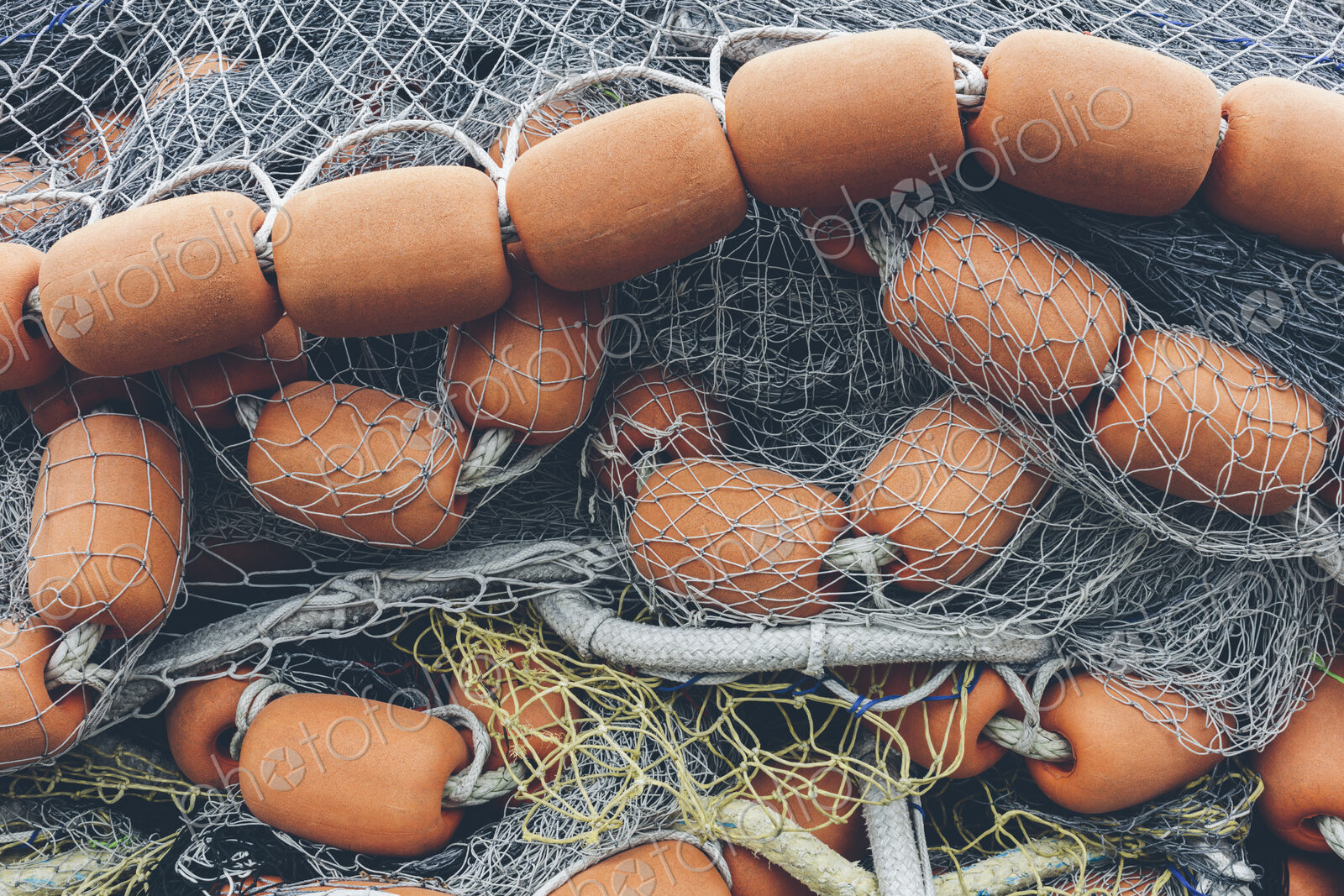 Pile of commercial fishing nets and gill nets on a fishing quay.