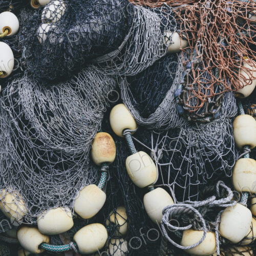 Pile of commercial fishing nets and gill nets on a fishing quay.
